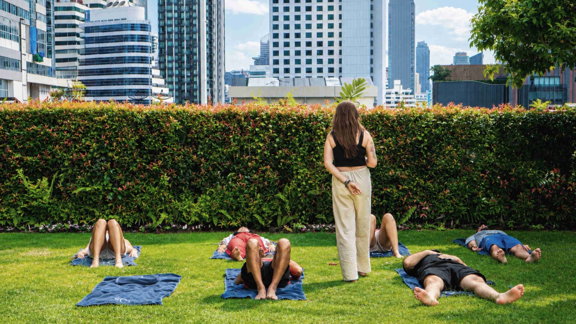 Guest relaxing on a sun lounger beside the swimming pool at Rembrandt Residences Bangkok in Sukhumvit.