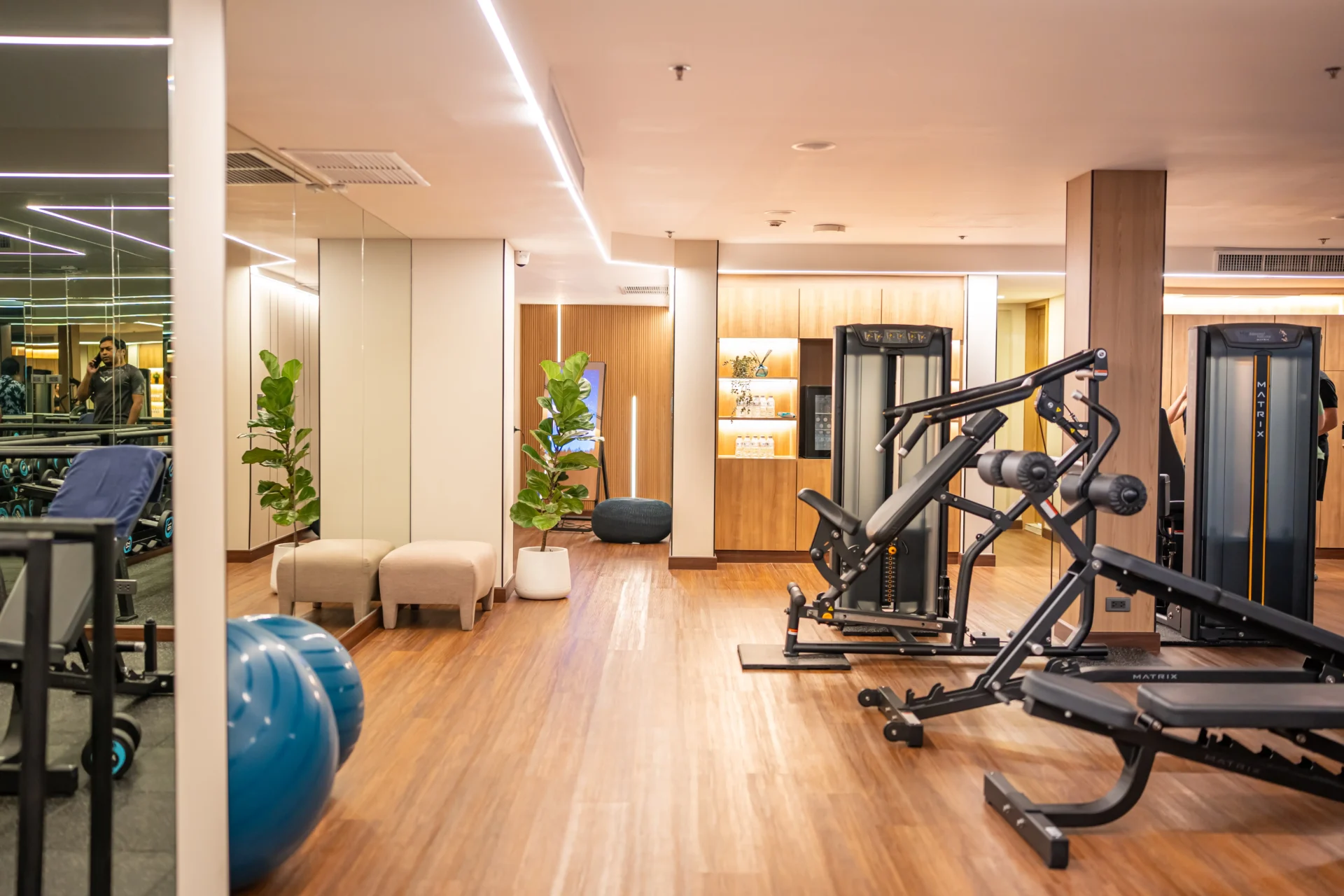 Modern hotel gym in Bangkok with city view, clean design, and fitness equipment
