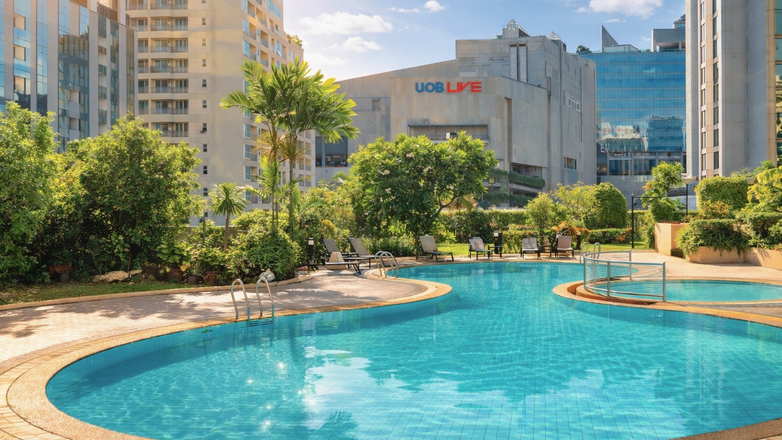 Outdoor swimming pool at a Bangkok hotel with city skyline views in a bright daytime setting